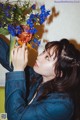 A woman holding a bouquet of flowers in front of her face.