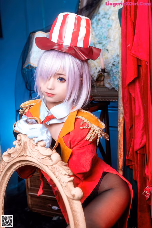 A woman in a red and white top hat sitting on a chair.