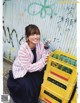 A woman sitting on the ground holding a bottle of water.