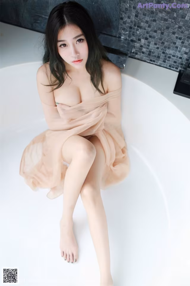 A woman sitting in a bathtub with her legs crossed.