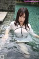 A woman in a white shirt is standing in a pool.