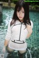 A woman in a white shirt is standing in a pool.