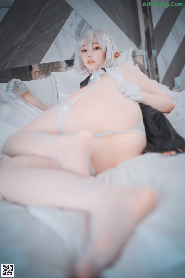 A woman laying on top of a bed in lingerie.