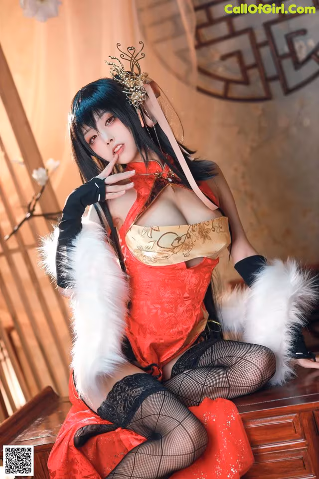 A woman in a red dress sitting on a wooden table.