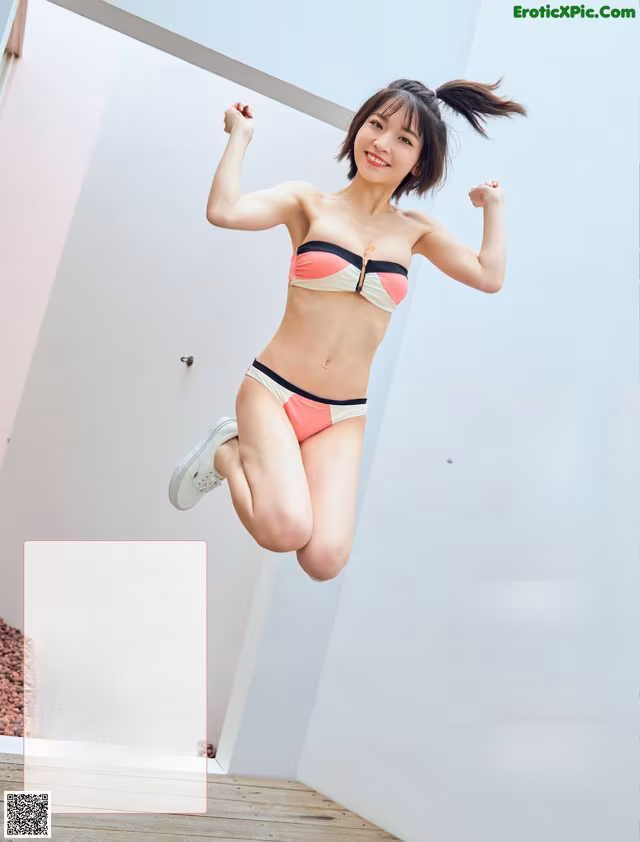 A woman in a bikini jumping in the air.