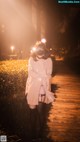 A woman wearing a mask standing on a boardwalk at night.