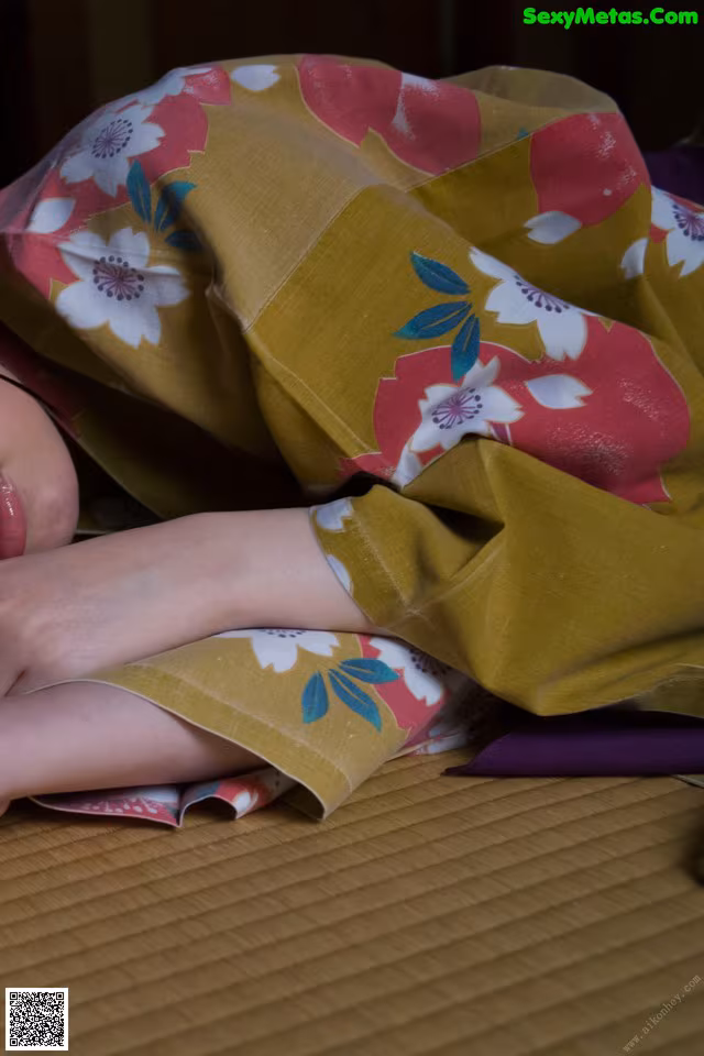 A woman laying on top of a bed covered in a blanket.