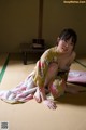 A woman in a kimono sitting on a tatami mat.