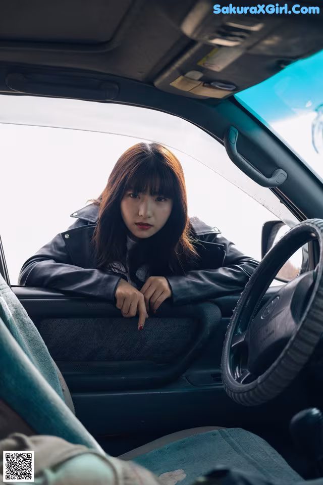 A woman sitting in the driver's seat of a car.